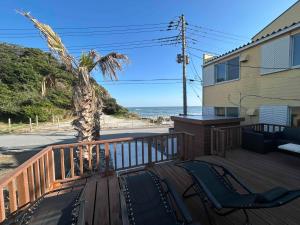 a deck with chairs and a palm tree on a house at いすみスローライフ in Chōjamachi