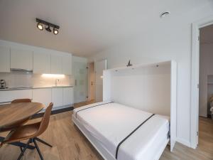 a bedroom with a bed and a table and a kitchen at Apartment in Middelkerke with balcony in Middelkerke