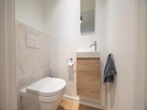a white bathroom with a toilet and a sink at Apartment in Middelkerke with balcony in Middelkerke