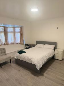 een slaapkamer met een bed, een stoel en een raam bij Marvel homes in Upchurch