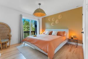 une chambre avec un lit orange et une fenêtre dans l'établissement Boho Vibes Cottage, à Sainte-Lucie-de-Doncaster