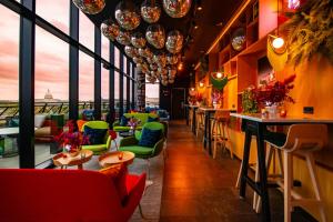 un restaurante con sillas coloridas, mesas y ventanas en citizenM Washington Capital, en Washington