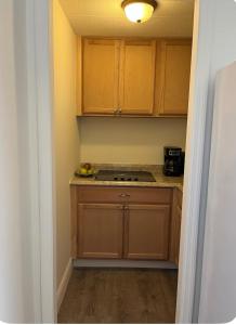 a small kitchen with wooden cabinets and a stove at Cozy private room in Princeton