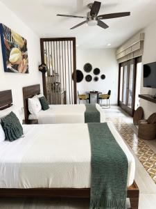 2 camas en un dormitorio con ventilador de techo en Latino Hotel Boutique, en Tulum