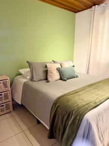 a bedroom with a bed with pillows on it at NaCasinha in Resende