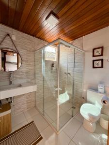 a bathroom with a glass shower and a toilet at NaCasinha in Resende