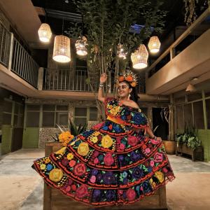 a woman in a colorful dress in a room at Xelva Hostel & Travel community in San Cristóbal de Las Casas