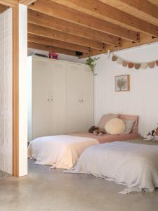 Un dormitorio con dos camas y techo de madera. en The Hillside Project, en Frankston South