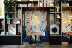 ロサンゼルスにあるcitizenM Los Angeles Downtownの青い椅子2脚とテーブルが備わる客室です。 +39枚の写真