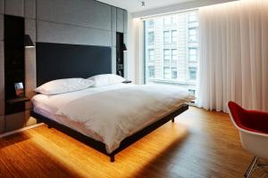 a bedroom with a large bed and a large window at citizenM Los Angeles Downtown in Los Angeles