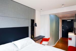 a bedroom with a bed and a red chair at citizenM Los Angeles Downtown in Los Angeles +40 photos
