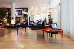 a room with a table with laptops on it at citizenM Los Angeles Downtown in Los Angeles