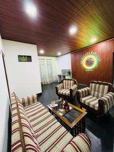 a living room with couches and a table in a room at Chamikara Homestay in Sigiriya