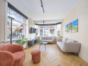 Miami WijkにあるHoliday Home in Middelkerke near beachのリビングルーム(ソファ、椅子、窓付)