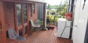 a patio with a table and chairs on a deck at Private cabin Close to airport in Auckland