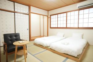 En eller flere senge i et værelse på Guest house ENJOY