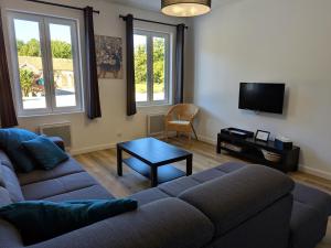 ein Wohnzimmer mit Sofa und Tisch in der Unterkunft Gîte en Sologne au calme avec étang, proche d'Orléans et châteaux, idéal randonnées et pêche - FR-1-590-242 in Vannes-sur-Cosson