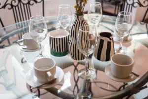 a glass table with wine glasses and a vase on it at Hermoso Apartamento in Cusco +9 photos