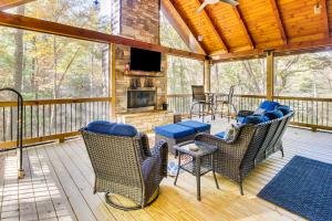 a screened in porch with chairs and a fireplace at Hot Tub and Creek View Cabin about 6 Mi to Ellijay! in Ellijay
