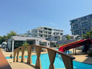 a playground in front of a pool with a slide at Utopia Loft Aparthotel by Sabai Sands in Rawai Beach +13 photos