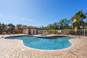 a swimming pool in a yard with a fence at Elegant Maui Banyan, Pool, Hot Tub, Across Kamaole II Beach Park in Wailea
