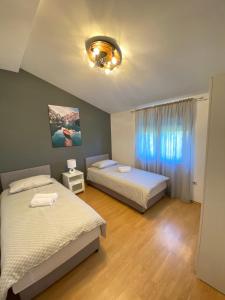um quarto com duas camas e uma janela em Family-friendly apartments with swimming pool Ljubac, Zadar - 14148 em Krneša mais 21 fotografias