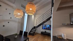 a dining room with two chandeliers and a staircase at BG Suite in Bergamo