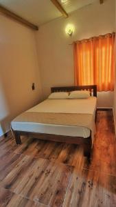 a bedroom with a large bed with a wooden floor at Eden Garden Bandipur Tiger Reserve in Gundlupet