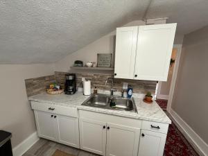 a kitchen with white cabinets and a sink at The Yellow Brick House in Geneva +9 photos
