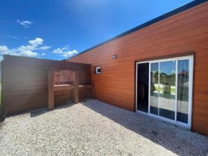 a building with a wooden wall with a window at Cabaña Zona Las Brusquitas in Miramar