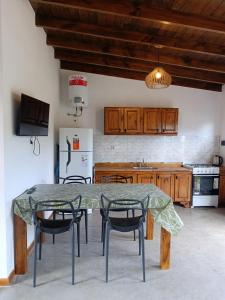 a kitchen with a table and chairs and a refrigerator at Cabaña Zona Las Brusquitas in Miramar