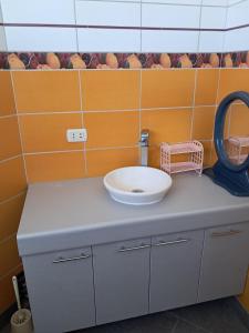 ein Badezimmer mit einem Waschbecken und einem Spiegel auf einer Ablage in der Unterkunft san andres, titikaka in Puno