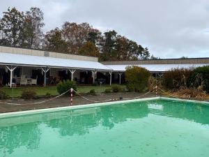 une grande piscine d'eau devant un bâtiment dans l'établissement 4 person holiday home in Nexø, à Strandby Gårde
