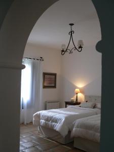 a bedroom with two beds and a chandelier at La Merced Del Alto in Cachí