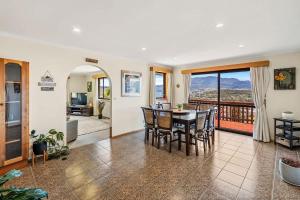 un salon avec une table et des chaises et un balcon dans l'établissement The Lookout with City water and Mountain views, à Bellerive