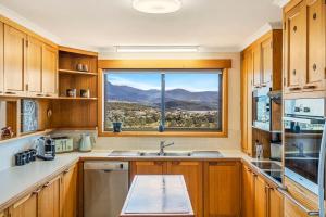 une cuisine avec une fenêtre avec vue sur les montagnes dans l'établissement The Lookout with City water and Mountain views, à Bellerive