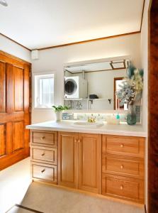 a kitchen with a sink and a mirror at wanpaku99一軒家貸切 in Chosei