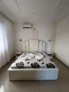 a white bed in a white room with at Appartement au centre-ville in Brazzaville