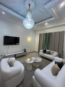 a living room with two white couches and a tv at Appartement au centre-ville in Brazzaville