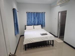 a bed in a small room with a blue curtain at Ban sabai pool villa in Ban Wang Phong