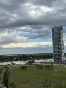a tall building next to a river with a building at Depto en Garden Puerto Santa Fe in Santa Fe