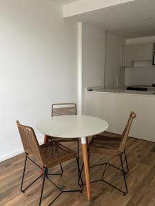 a white table with two chairs and a kitchen at Depto en Garden Puerto Santa Fe in Santa Fe +8 photos