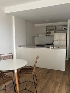 a kitchen with a table and chairs and a white counter at Depto en Garden Puerto Santa Fe in Santa Fe
