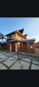 a large house with a fence in front of it at Pousada Kirana in Praia do Rosa