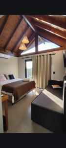a bedroom with two beds and a large window at Pousada Kirana in Praia do Rosa +95 photos