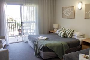 una habitación de hotel con una cama y un balcón en BATHURST GOLDFIELDS MOTEL at 428 CONROD STRAIGHT MOUNT PANORAMA, en Bathurst