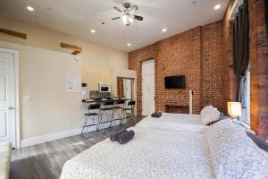 a bedroom with two beds and a brick wall at JGSTAY - Koreatown in New York