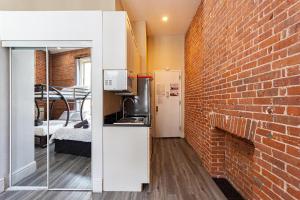 a brick wall divides a kitchen from a living room at JGSTAY - Koreatown in New York