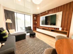 un salon avec une grande télévision à écran plat dans l'établissement Zuhause Apartments 5th AV, à Playa del Carmen