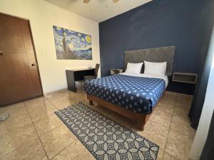 een slaapkamer met een bed met een blauwe muur bij Habitacion Arboleda in Saltillo